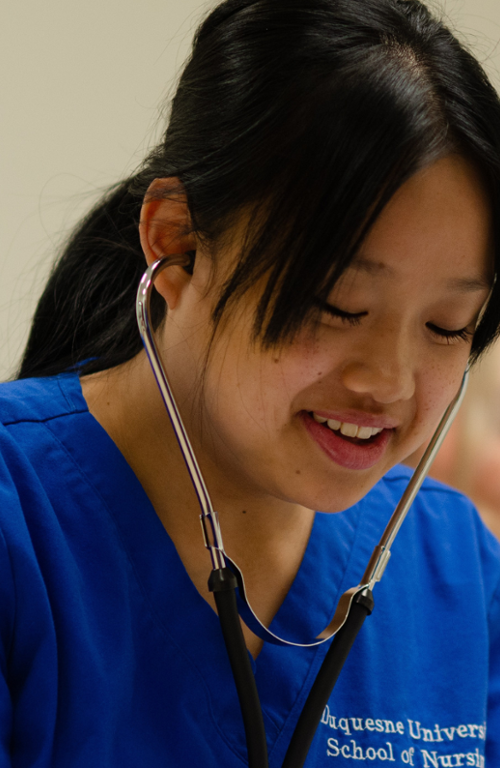 female nurse wearing scrubs listening to a patient