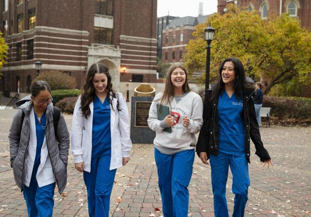 Four female BSN students walking campus