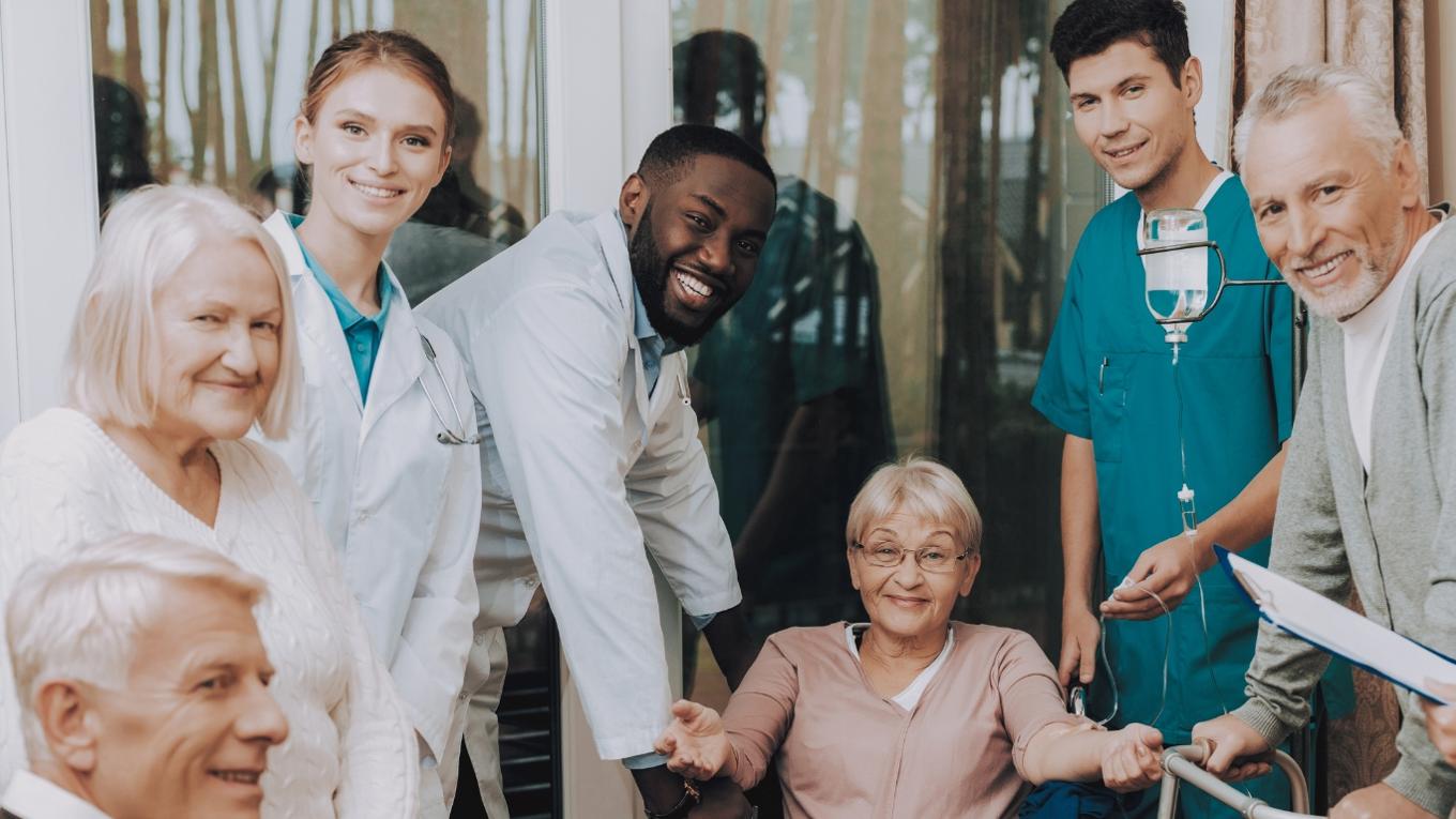 Elderly patient surrounded by family and care staff