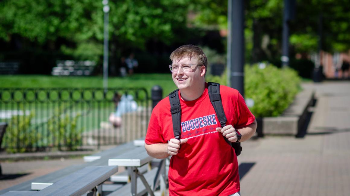 male nursing student walking on campus