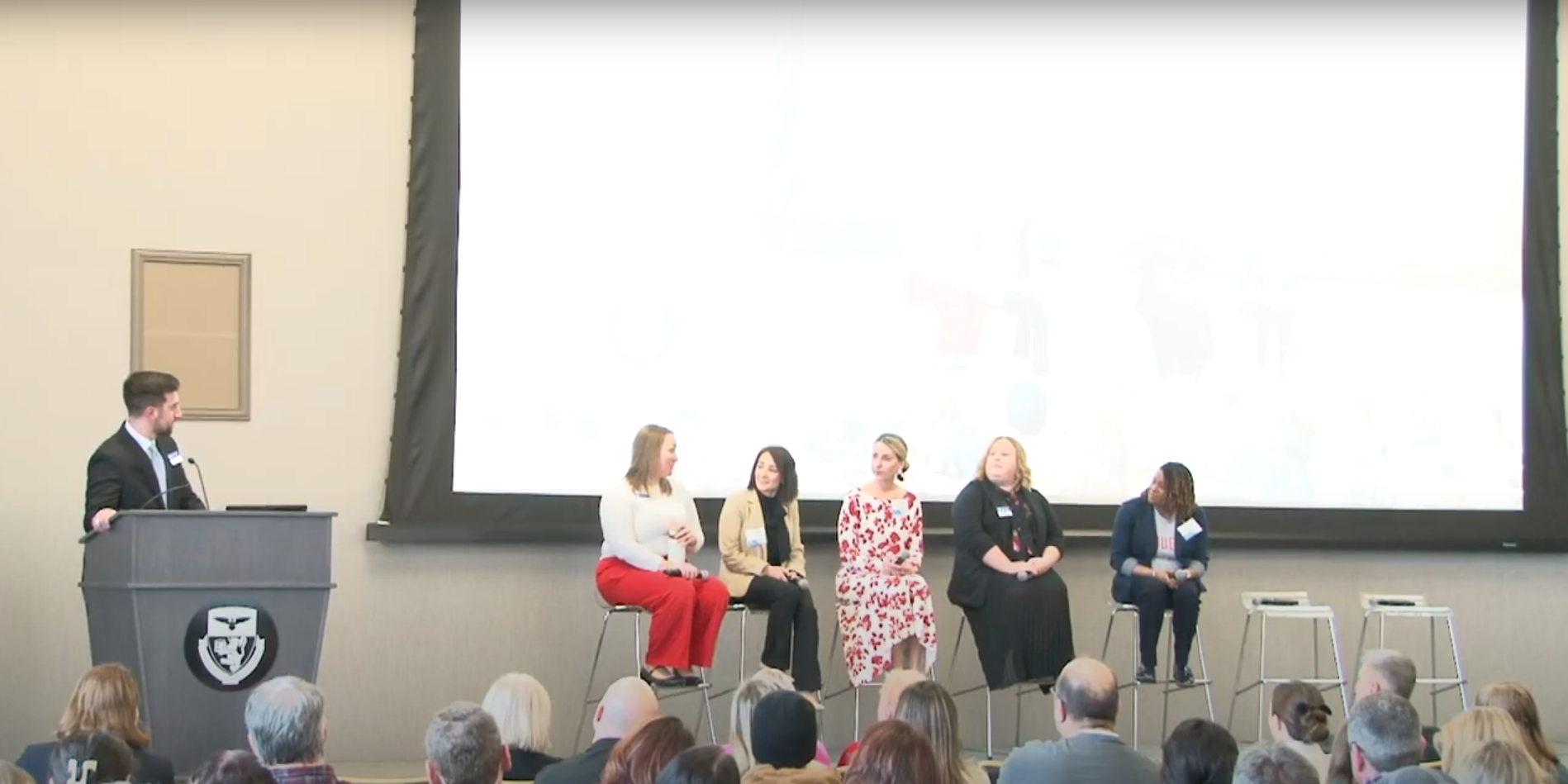 Staff and faculty members sit on stage for a panel discussion. 