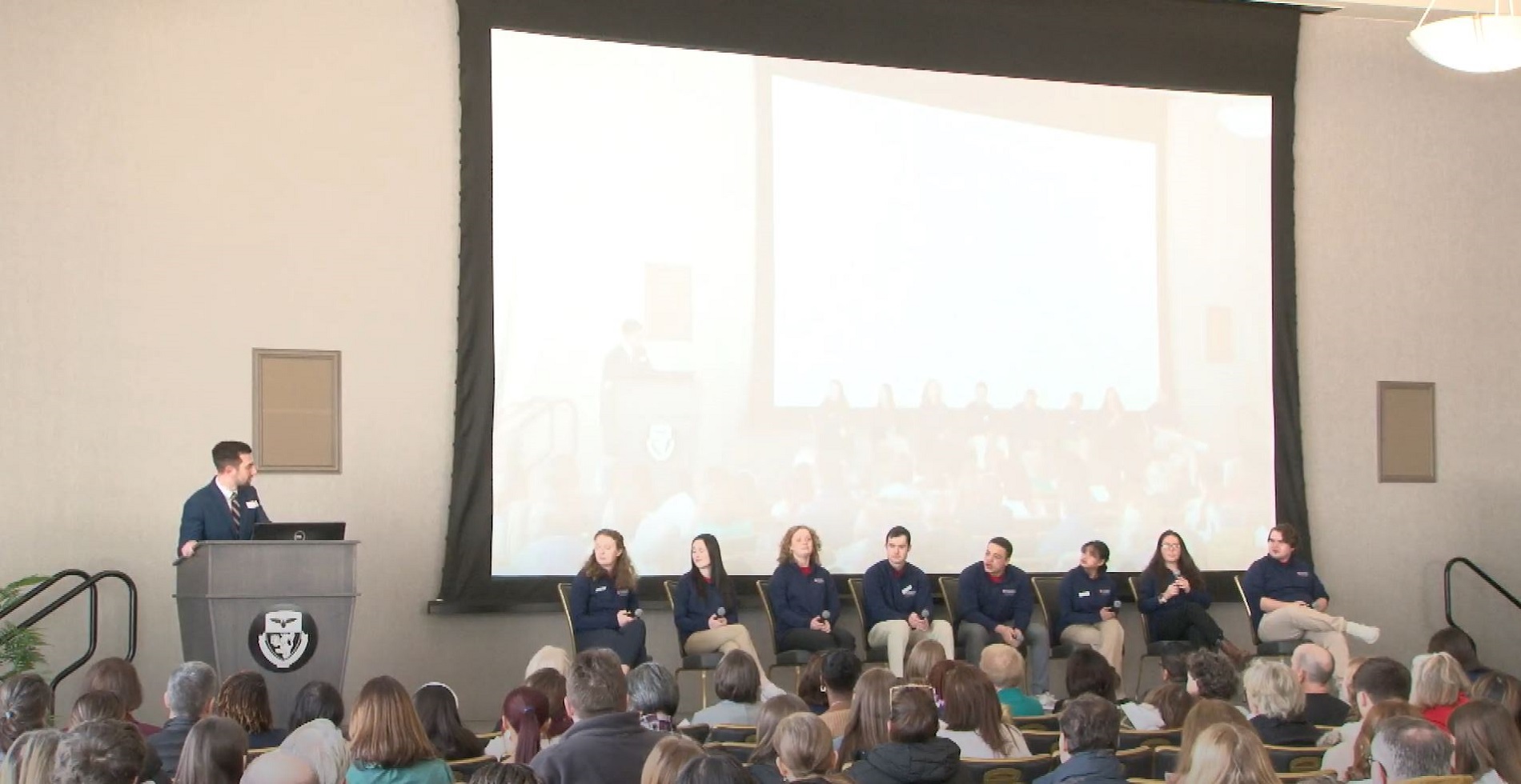A group of students sit on a stage for a panel discussion. 