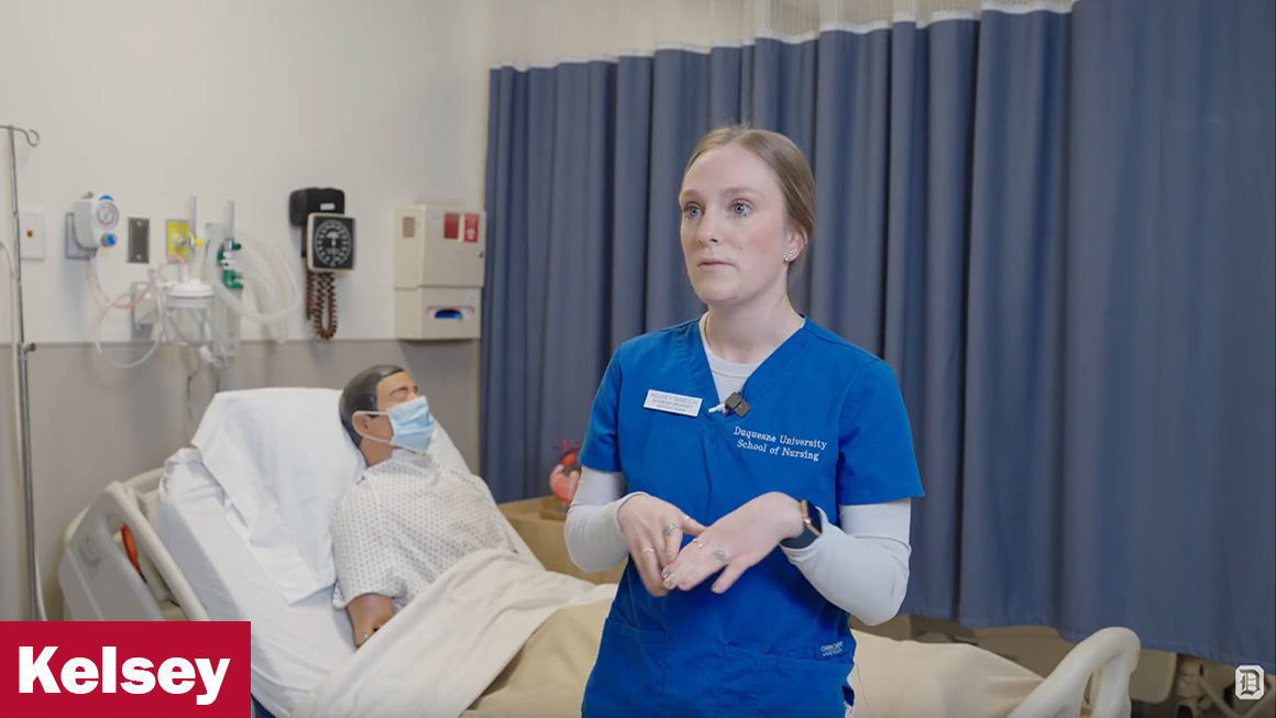 Kelsey dressed in scrubs in the lab