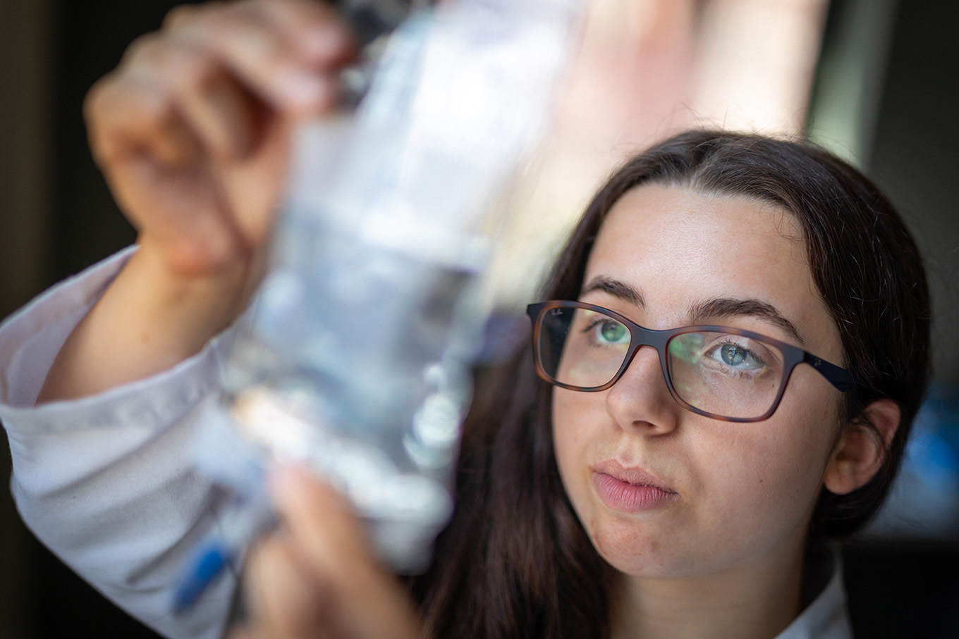 A student holding up an IV bag