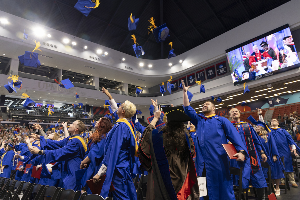 graduates throwing their caps in the air