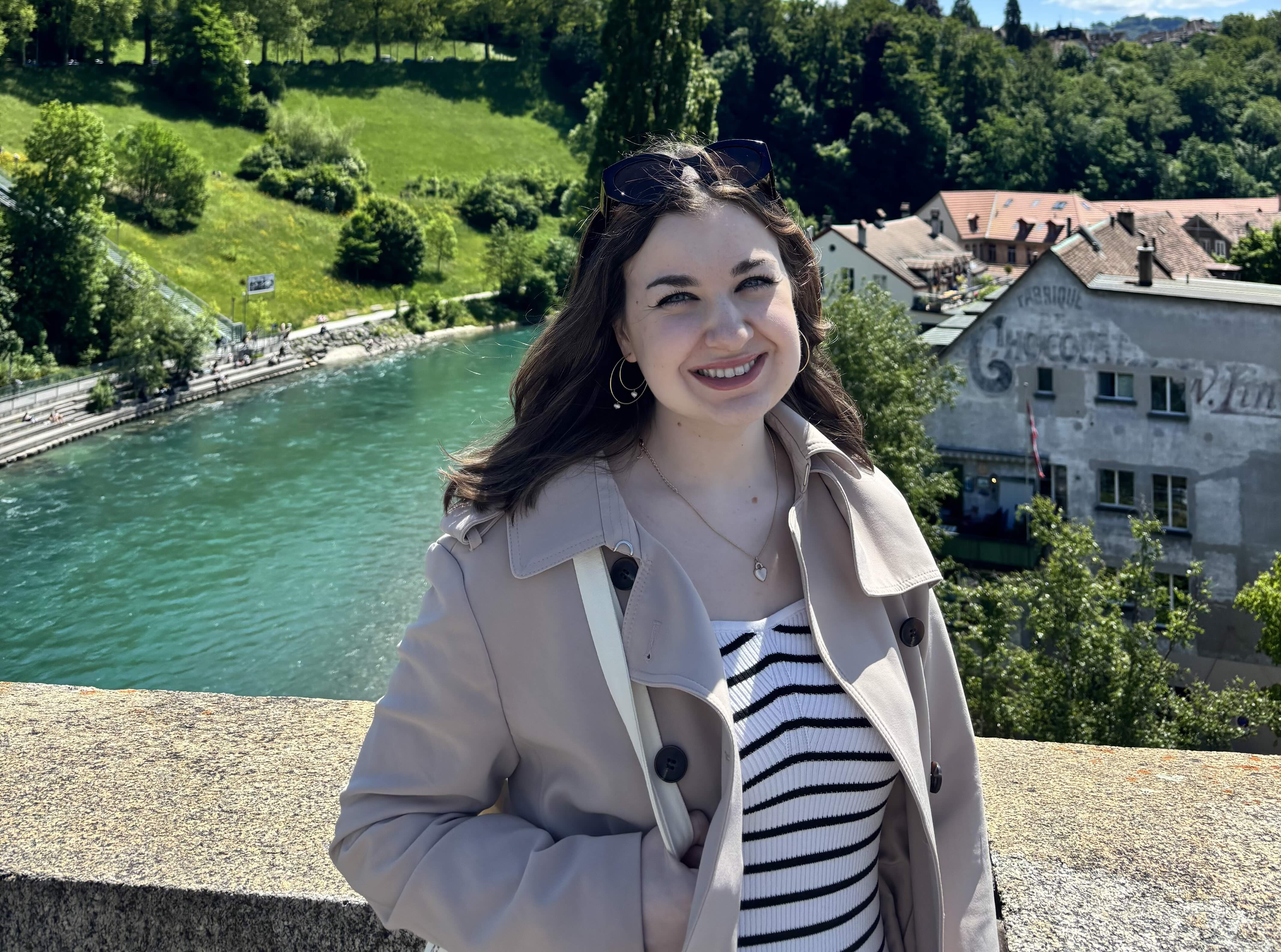 a girl in front of a pond and a building