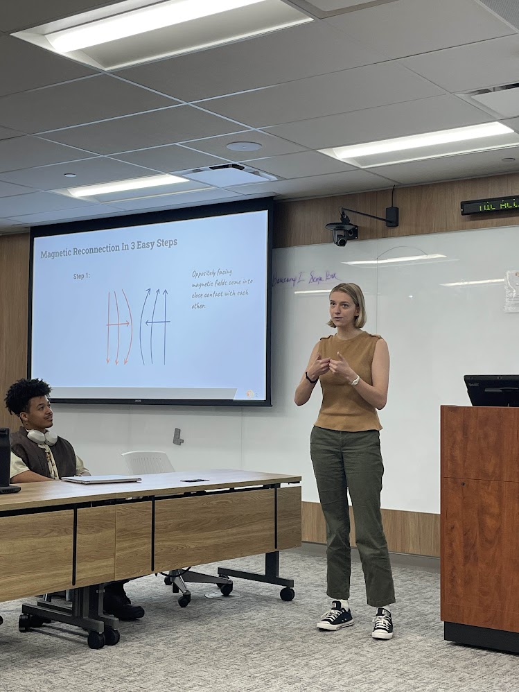 a girl in front of a powerpoint giving a talk