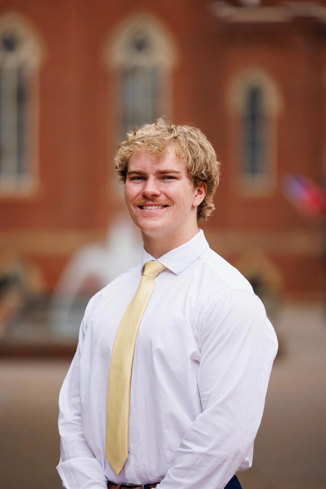 a male in a white shirt and tie