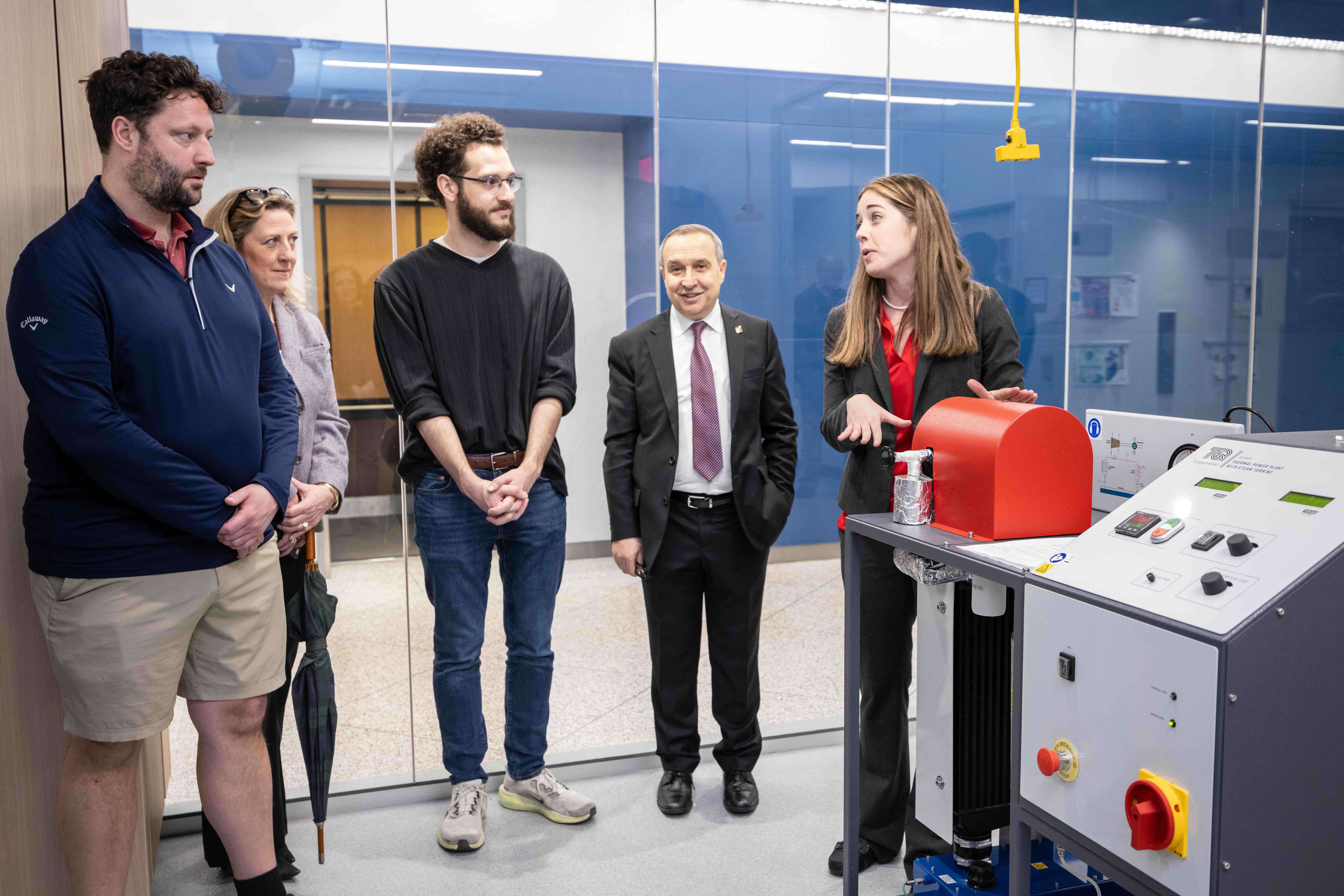 a group of people and a piece of equipment in a lab
