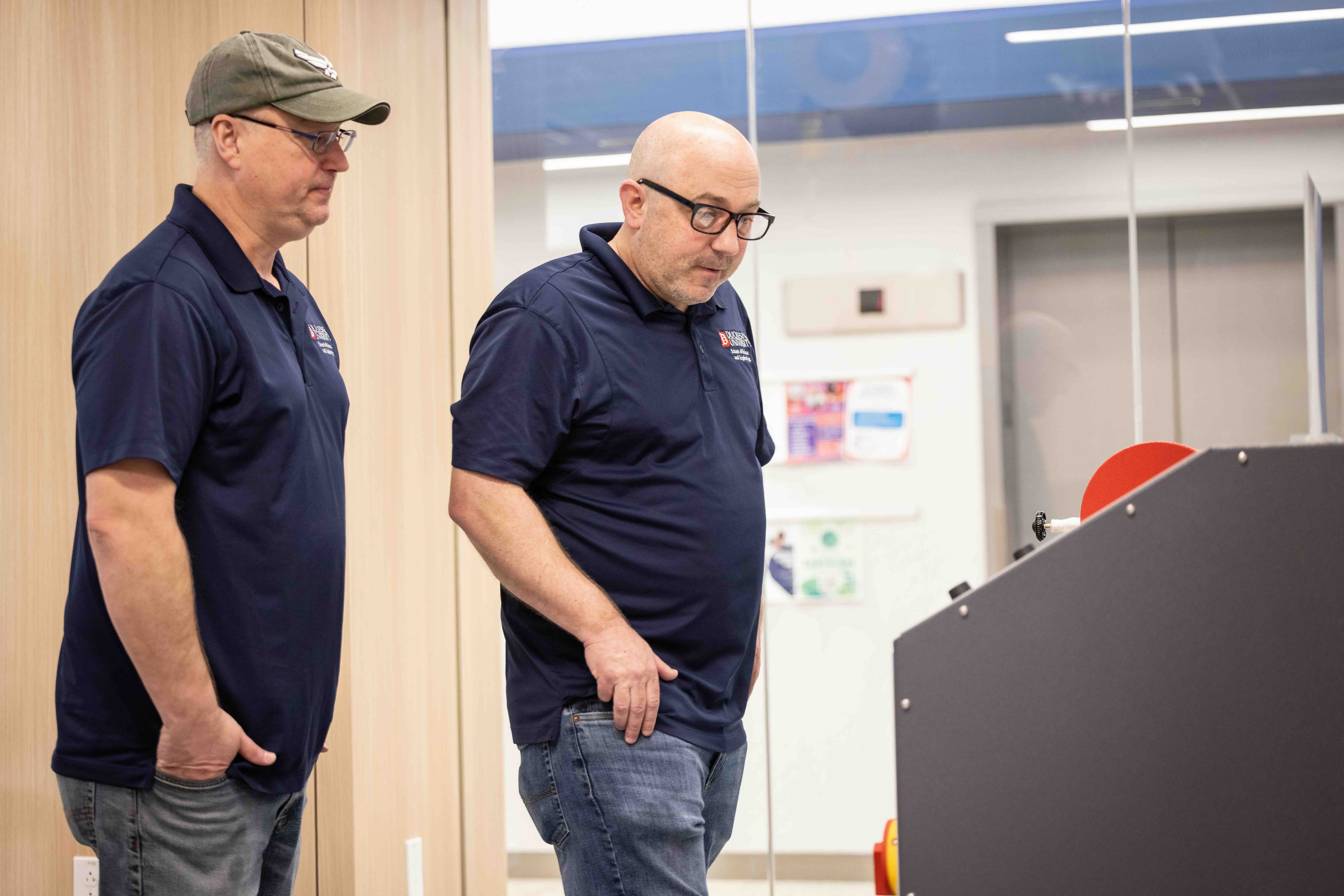 two people looking at a piece of equipment