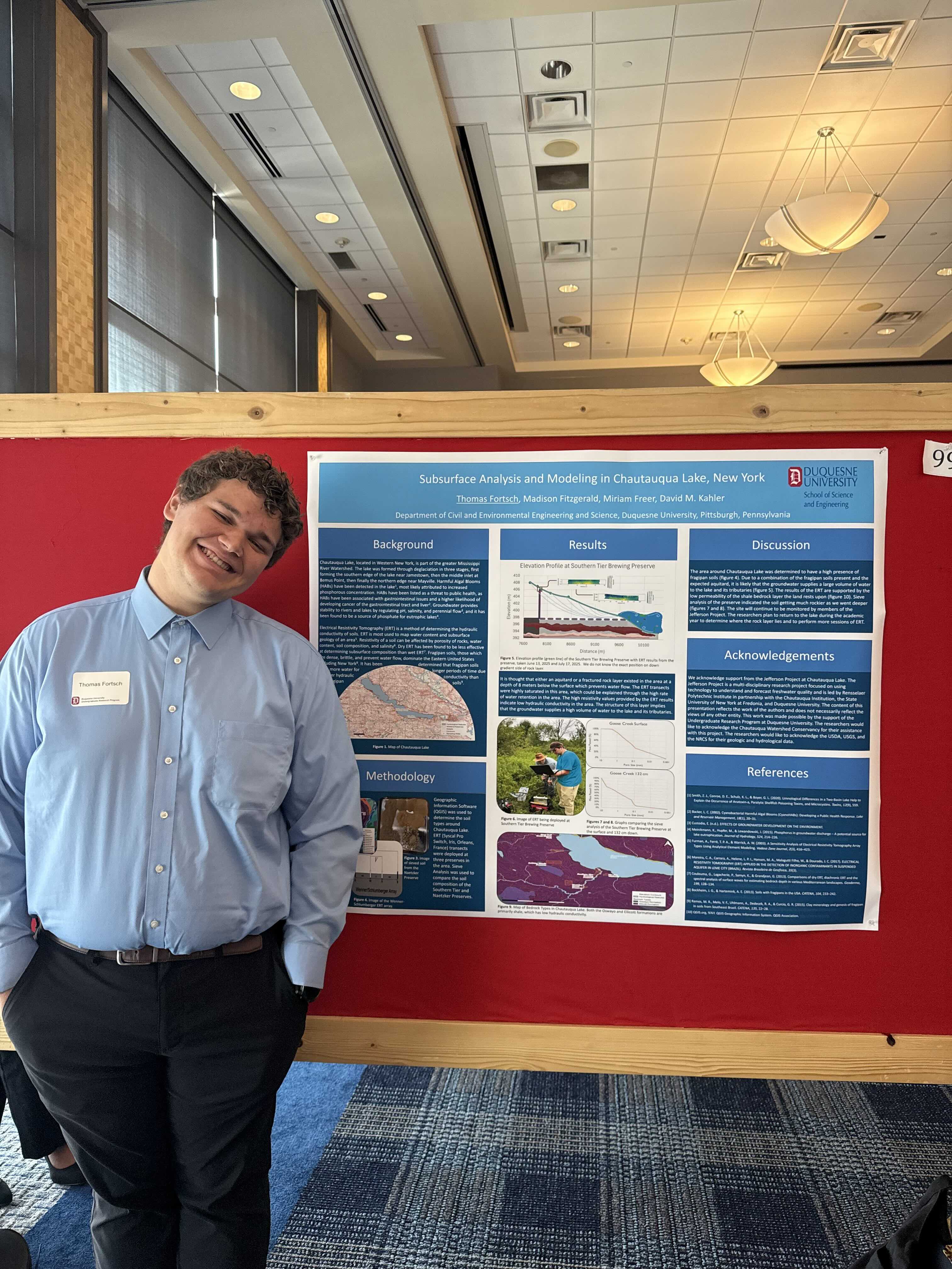 a male standing in front of a poster