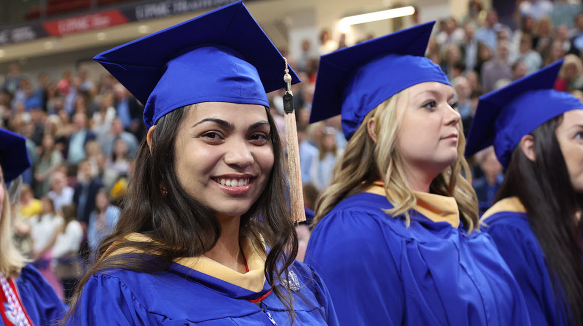 a proud Duquesne student at commencement next to other graduates