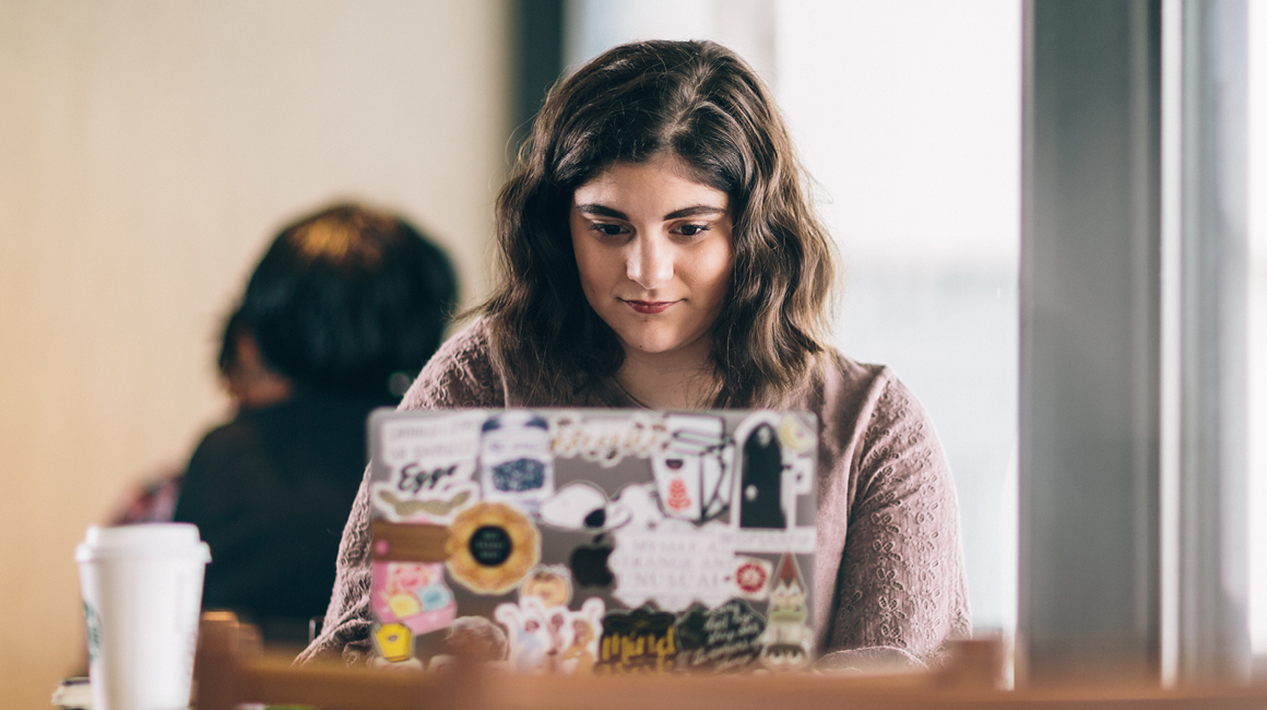 student working on laptop on campus