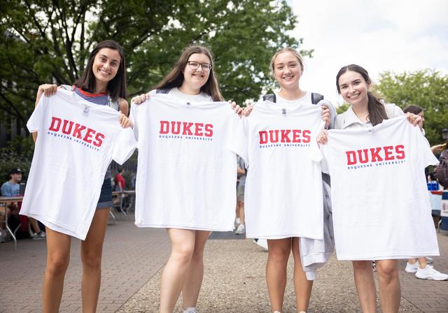 students holding shirts