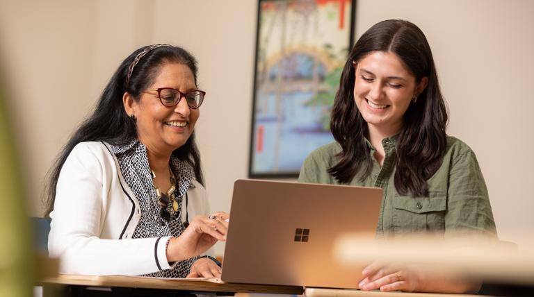 success coach helping a student working on her laptop