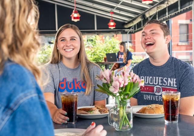 Students eating on Moonlit Burgers outdoor patio