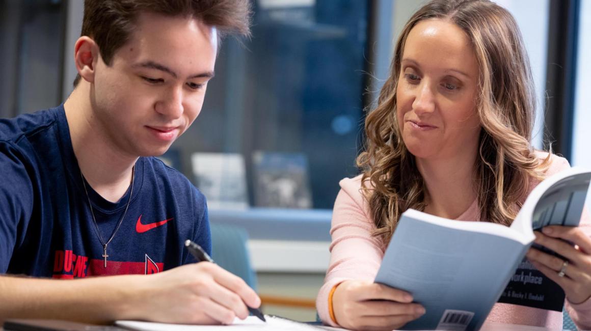 students working together with a book