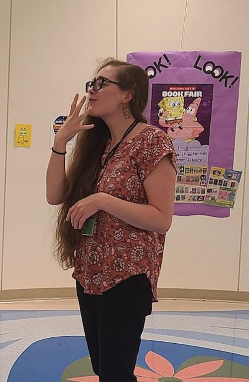 Brooke Yurick speaking with a colleague at her workplace, Maryland School for the Deaf