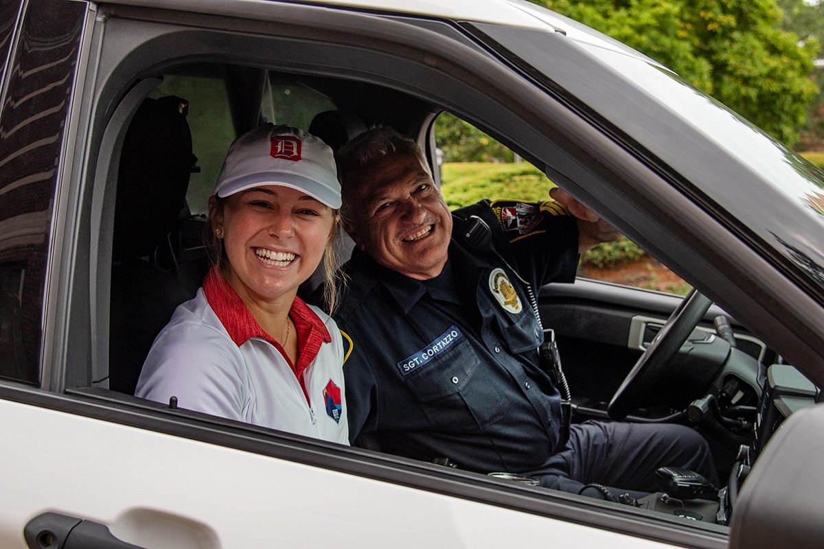 A DU Officer and Student smile for the camera