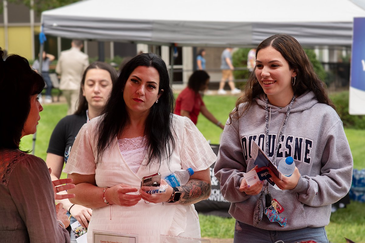 A mother and daughter talk with a DU volunteer during check-in