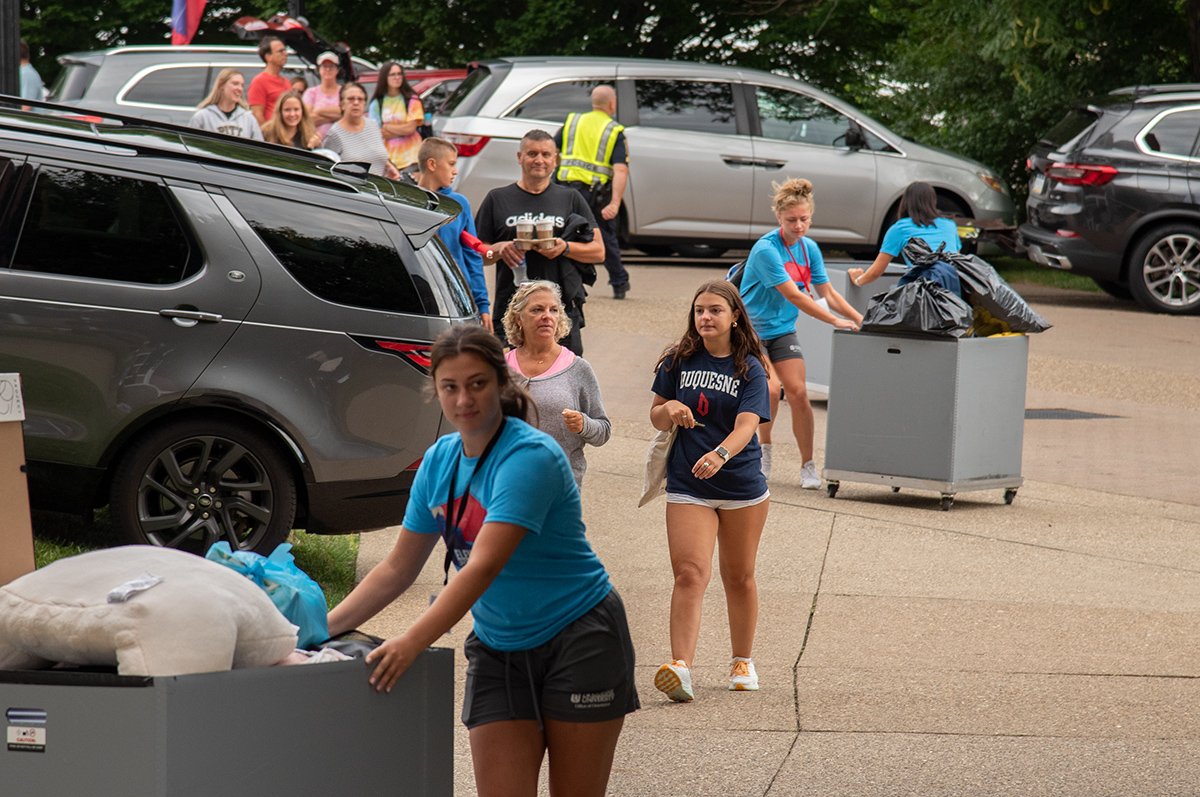 DU student workers push carts for incoming freshman and their families.