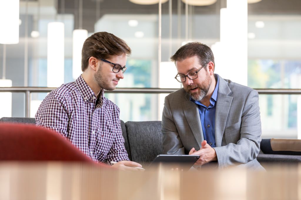 Staff explaining something to a student during a meeting