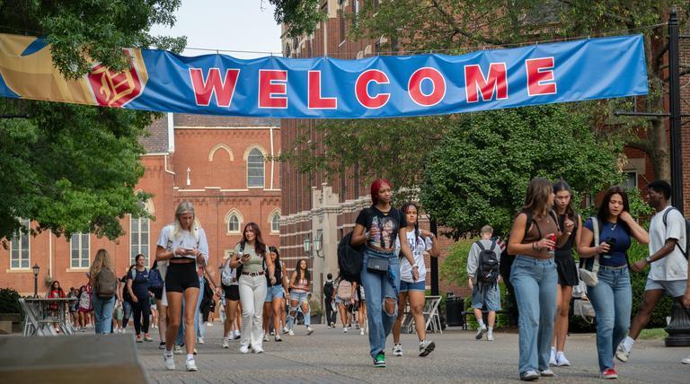 Students on academic walk with welcome banner hung.