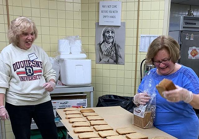 Alumni preparing sandwiches at Red Door Project