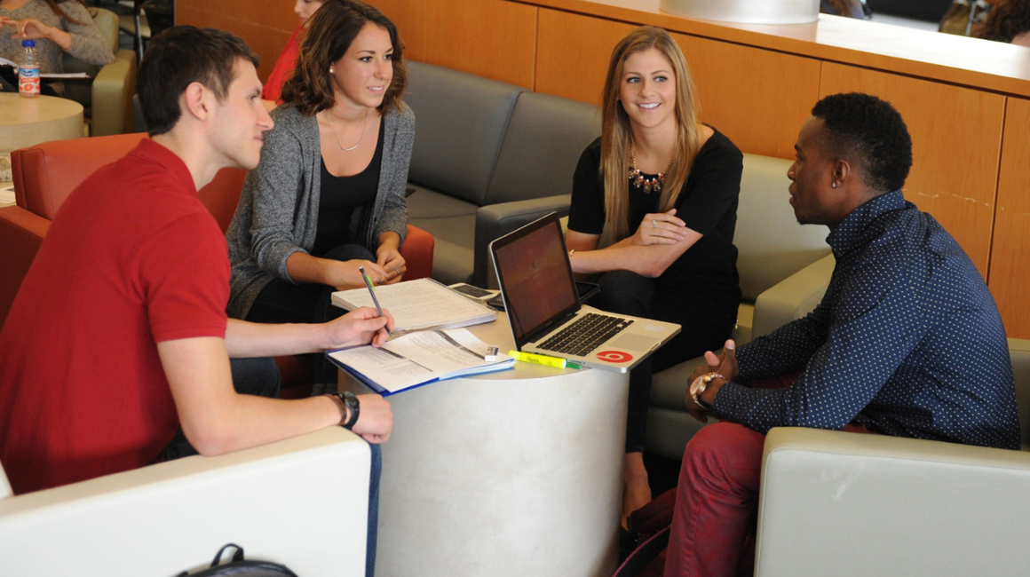 Four people sitting around a low table talking