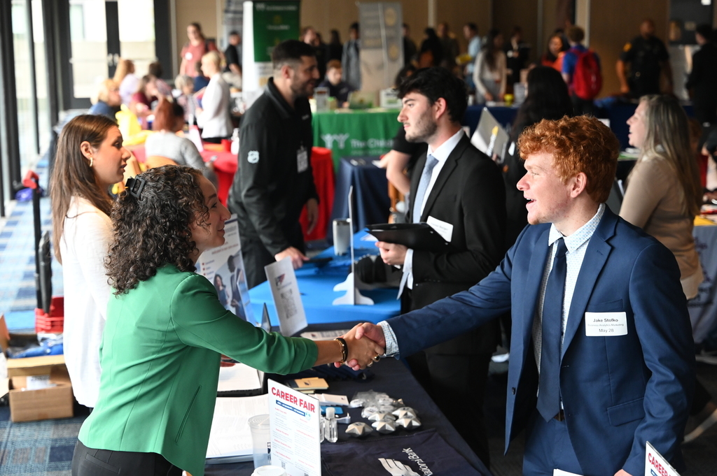 A student shakes hands with a potential employer in the Union Ballroom. 