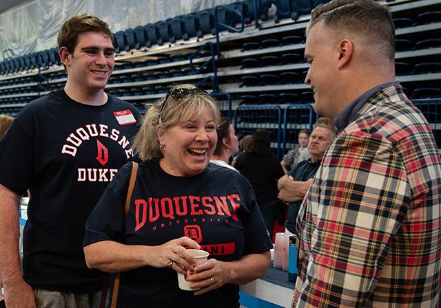A mom and her student joyfully converse with Dr. Adam Wasilko