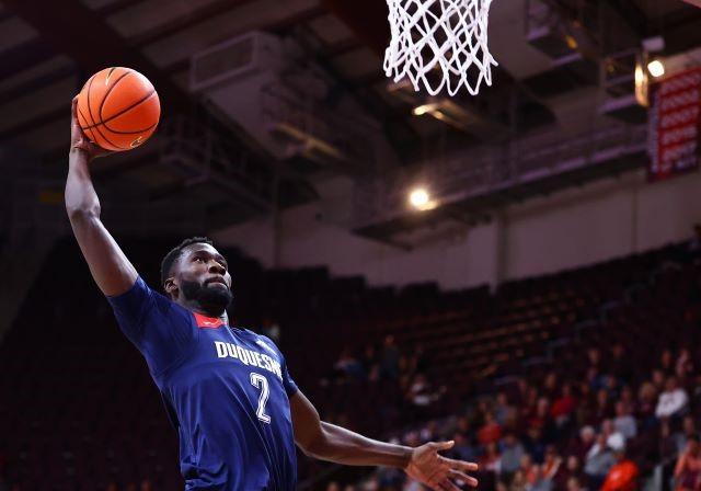 Duquesne men's basketball player, David Dixon, shoots and scores with a slam dunk!