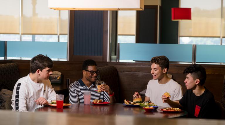 Students at the lunch table smiling
