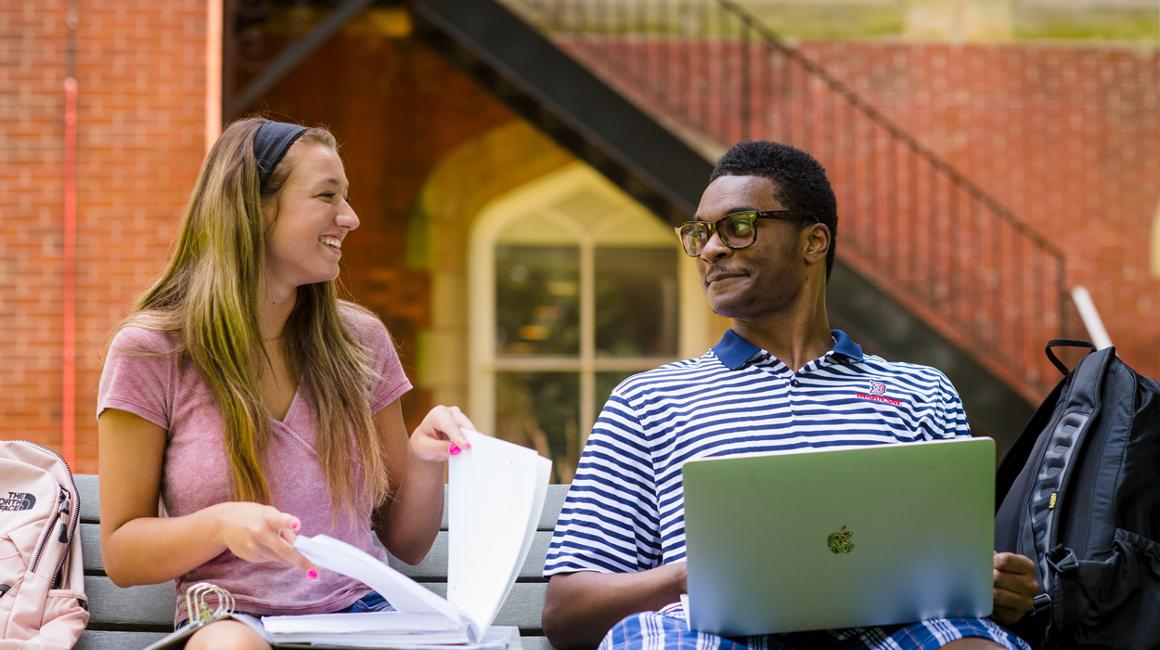 Gussin Students talking on a bench outside.