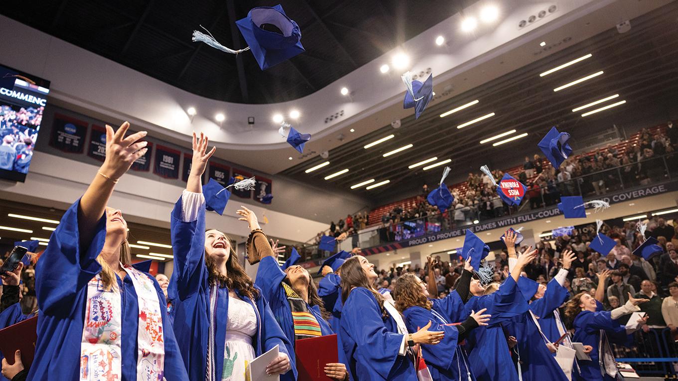 Graduates tossing caps in the air at Commencement