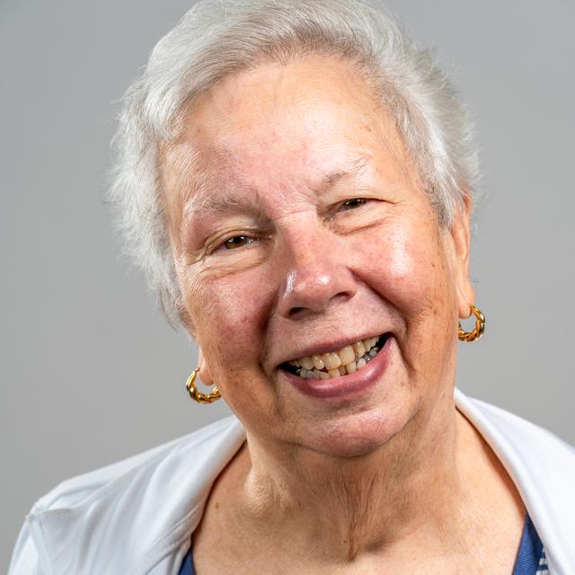 Ann Labounsky poses for a headshot in front of a gray background.