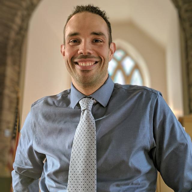 Dan Parasky poses for a headshot in a church.