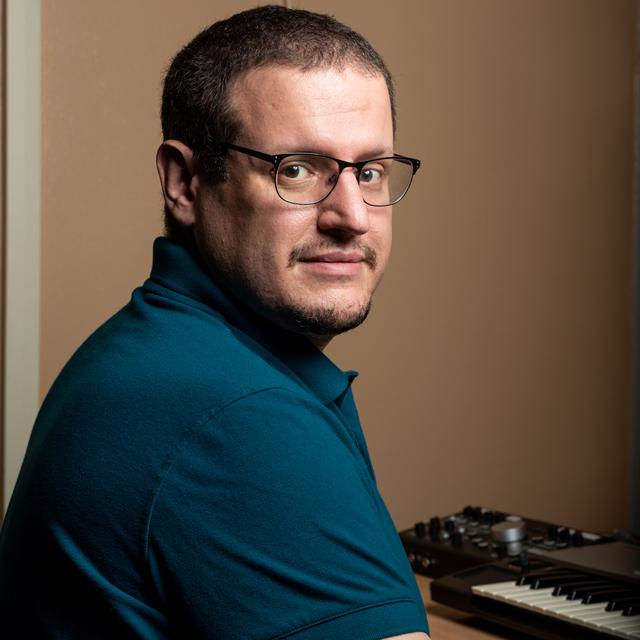 David Egyud poses for a headshot in front of a digital keyboard.