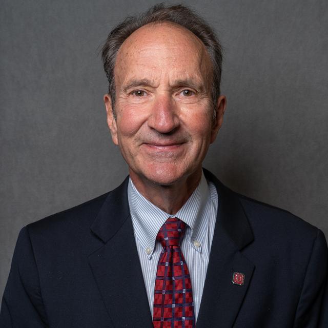 Edward Kocher poses for a headshot against a gray background.