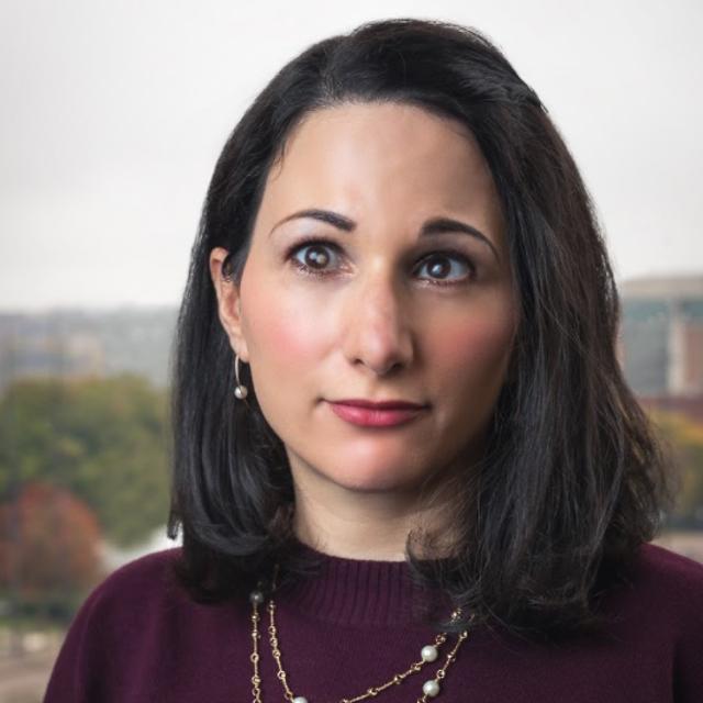 Headshot of Dr. Elizabeth McCallum with campus in background