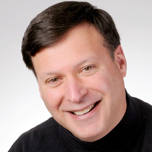 Jeffrey Mangone poses for a headshot in front of a white background.