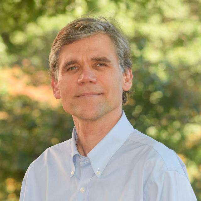 Headshot of Dr. Jered Kolbert outside on campus with trees in background