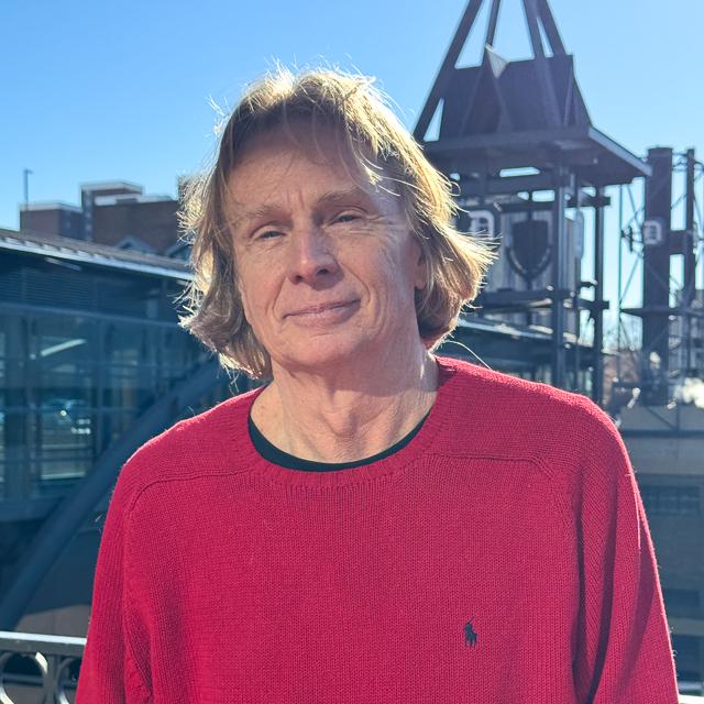  Headshot of Dr. Kush with Duquesne skywalk with D emblem on it and campus buildings in background