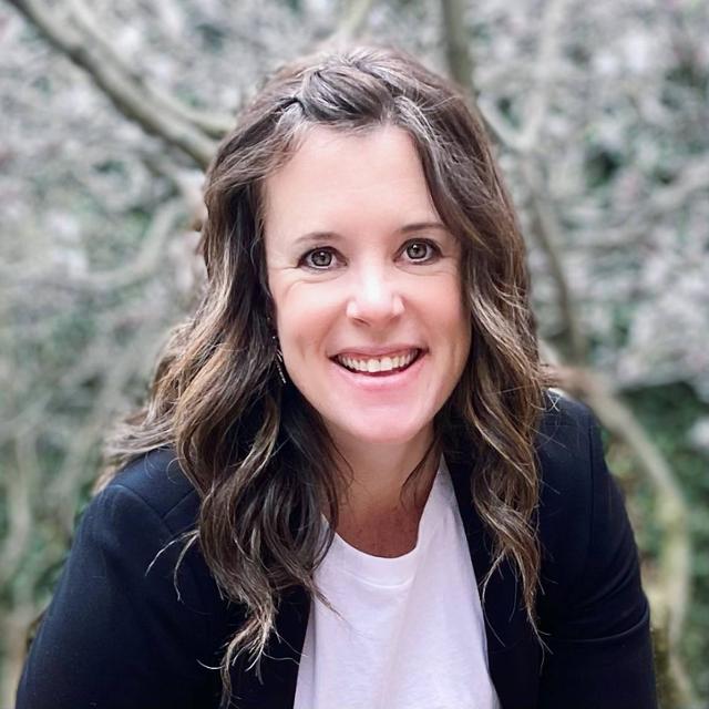 Professional photo of Kate Sheridan outside with a tree behind her