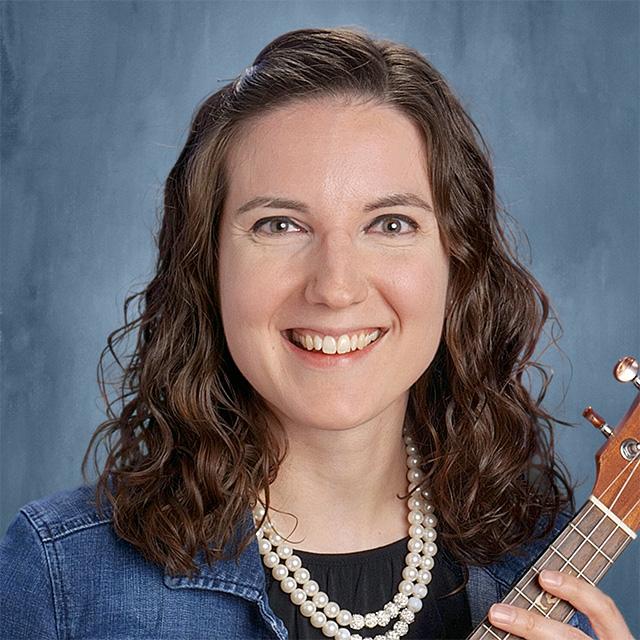 Kayla Kurtz poses for a headshot against a blue background.