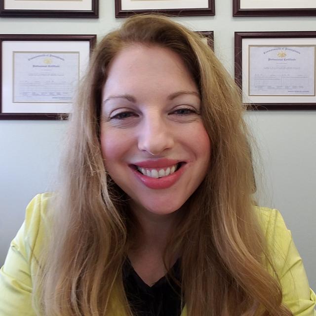 Headshot of Dr. Laura Crothers on in office with framed degrees behind her