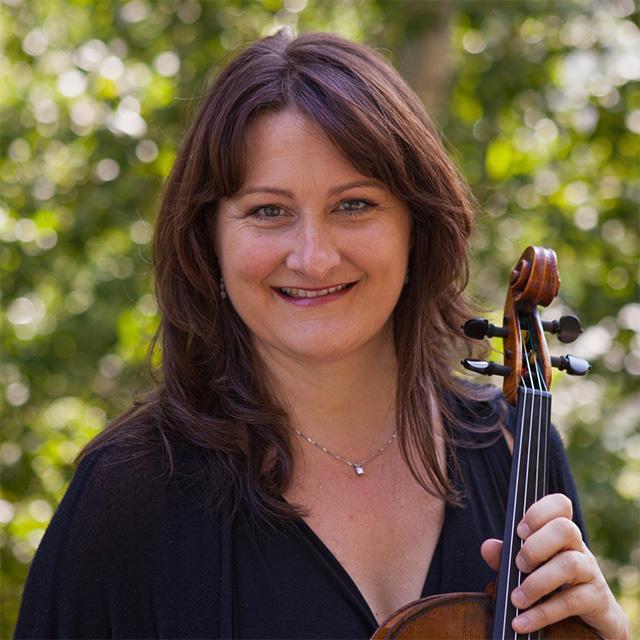 Marylène Gingras-Roy poses with viola in front of trees.