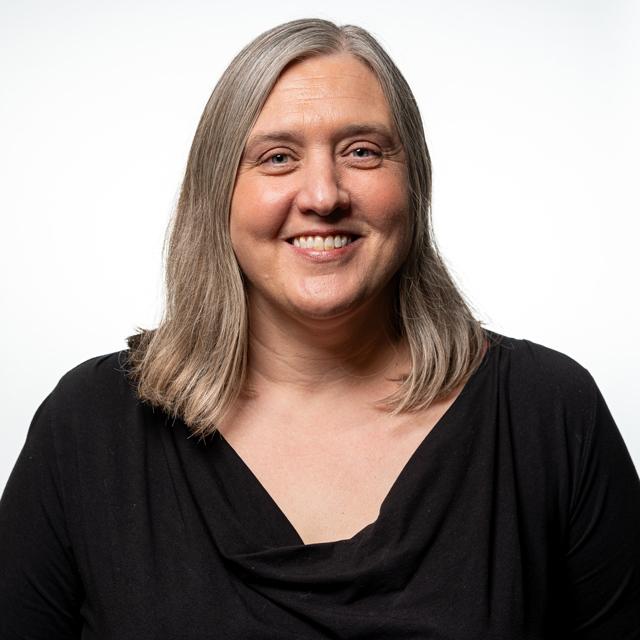 Mary Lynne Bennett poses for a headshot on front of a white background.