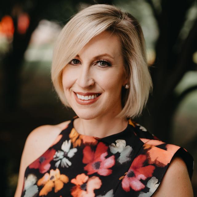 smiling blonde woman in a floral dress