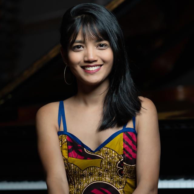 Pianist sitting in front of piano.